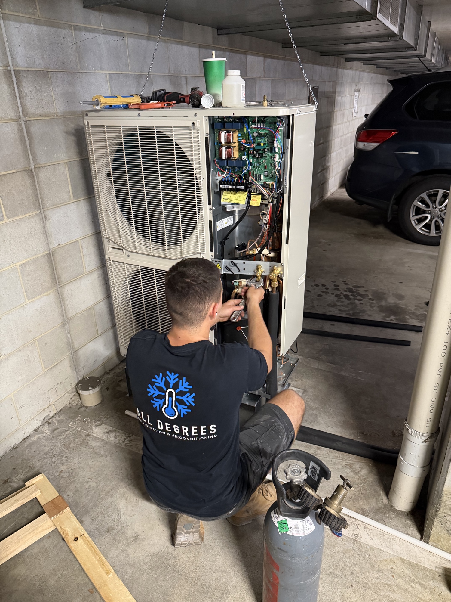 All Degrees technician servicing a Mitsubishi Heavy Industries outdoor unit