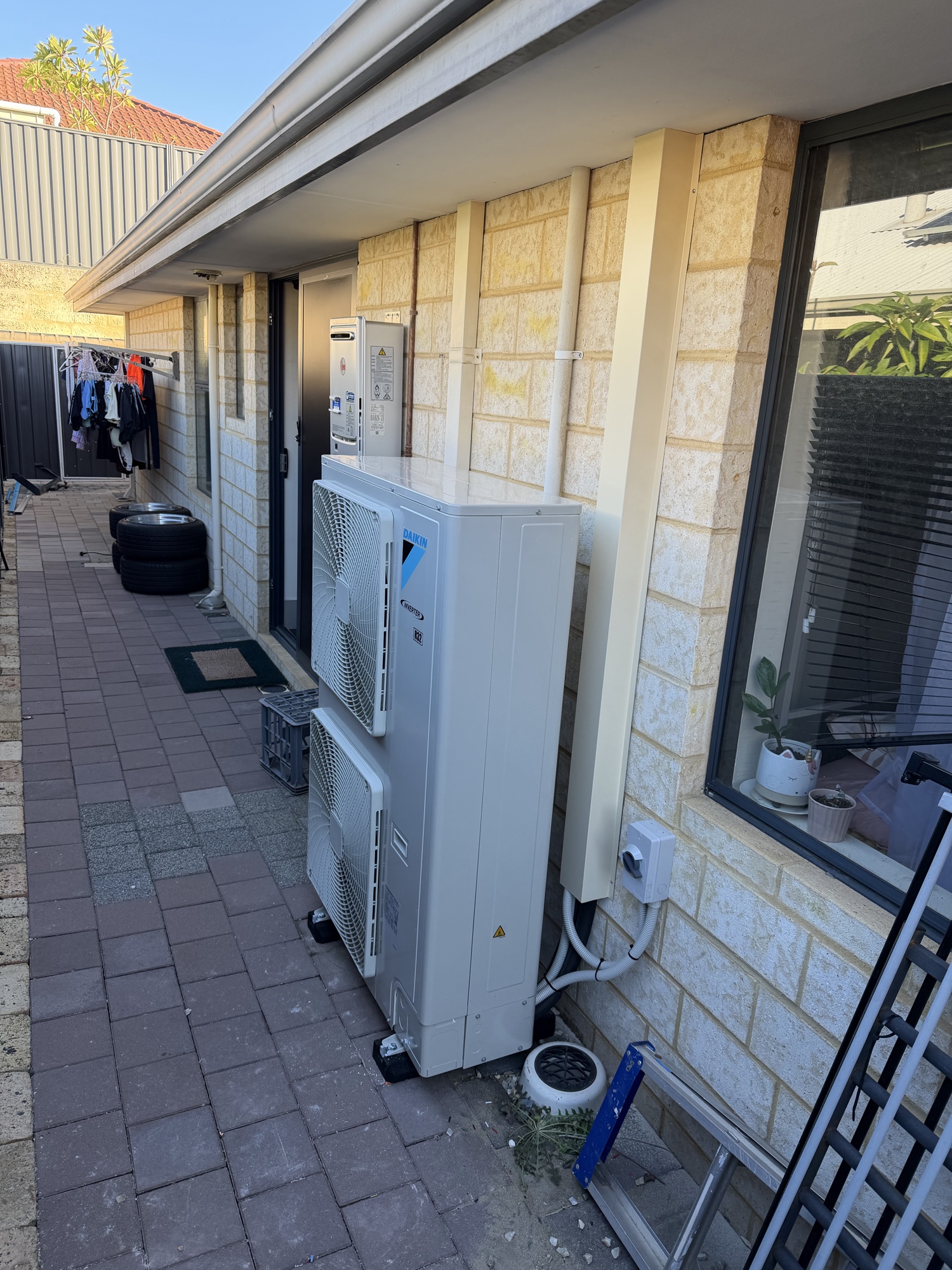 Large Daikin ducted outdoor unit installed in residential courtyard